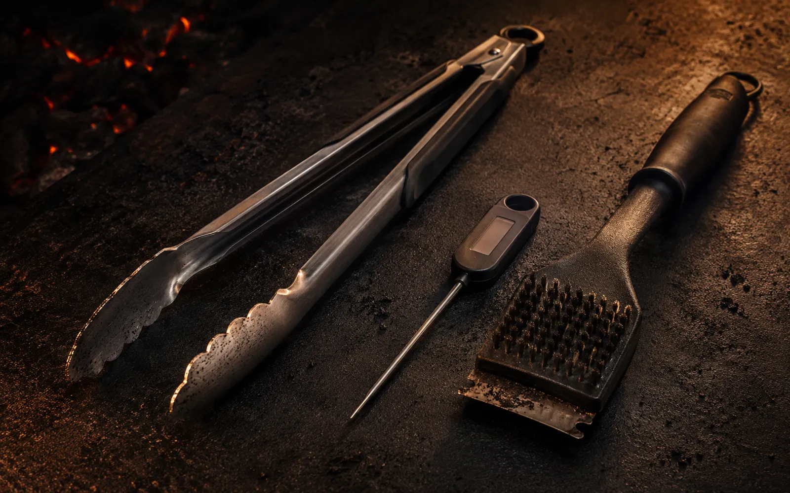 Grilling tools including tongs, thermometer, and grill brush